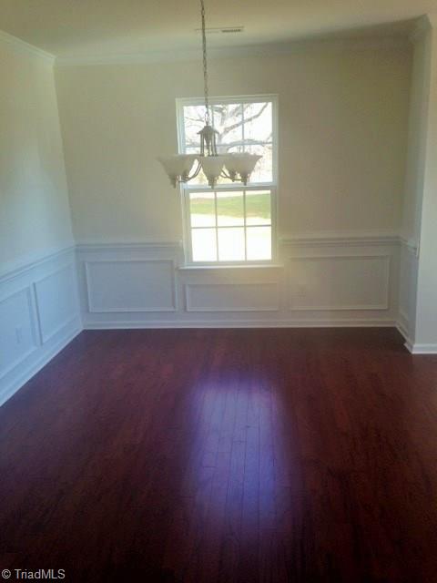 Formal Dining room. Actual home does not have crown molding, chair rail or shadow boxing. This picture is from the same plan but only demonstrates the size of the room. Hardwoods are not in actual home.