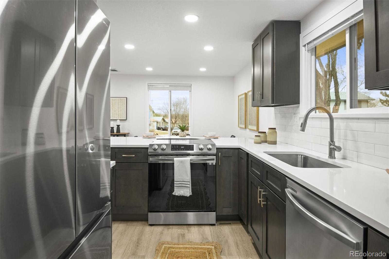 9340 Pierce Street Westminster, CO 80021 - Photo 13 of 29 a kitchen with stainless steel appliances granite countertop a sink a stove and a refrigerator