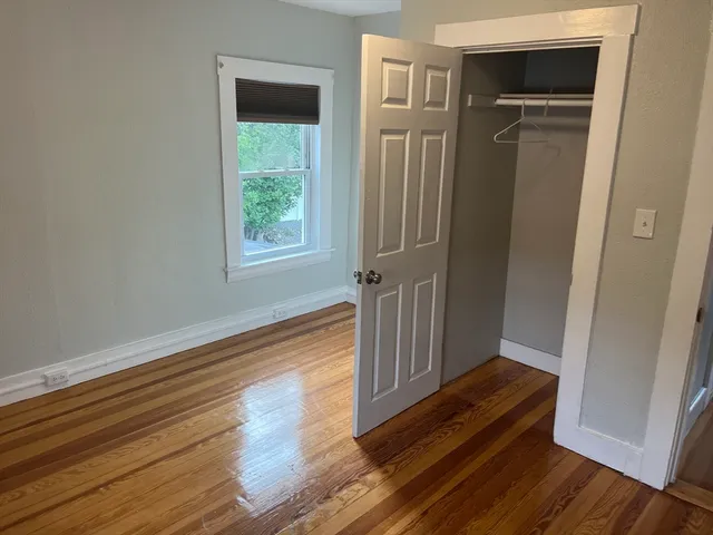 a view of a hallway with wooden floor and a window