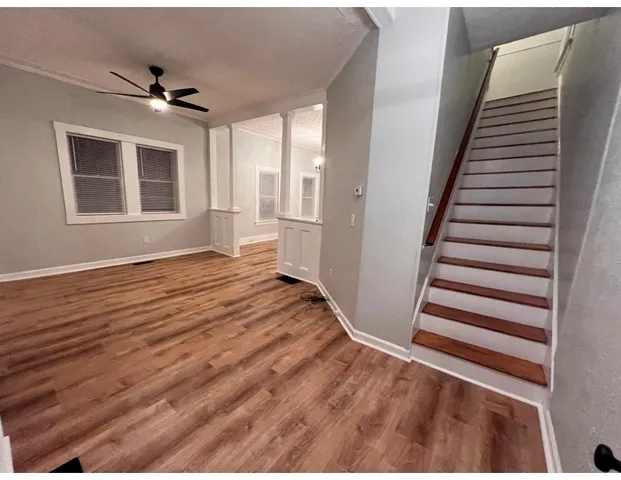 a view of a livingroom with wooden floor and stairs