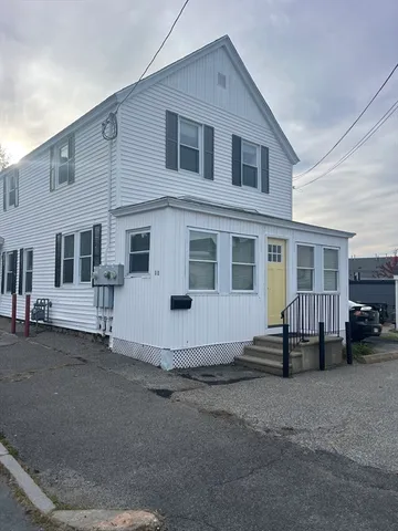 a white building with a large window and car parked