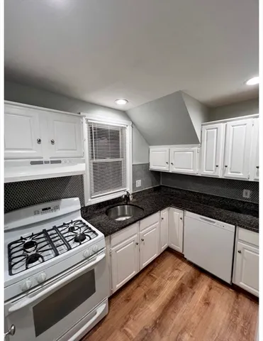a kitchen with granite countertop a stove and a sink