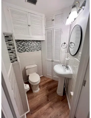 a bathroom with a toilet a sink and a mirror