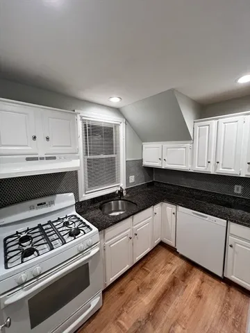 a kitchen with granite countertop a stove and a sink
