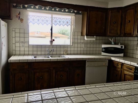 1321 South McCall Street Ridgecrest, CA 93555 - Photo 20 of 23 a kitchen with a sink a stove and black cabinets