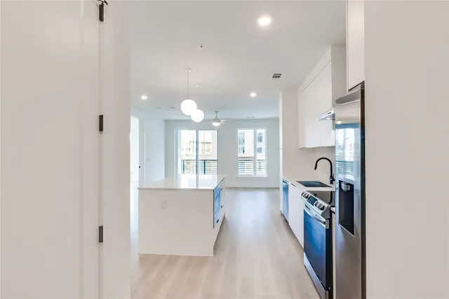 a view of a kitchen with a sink and wooden floor