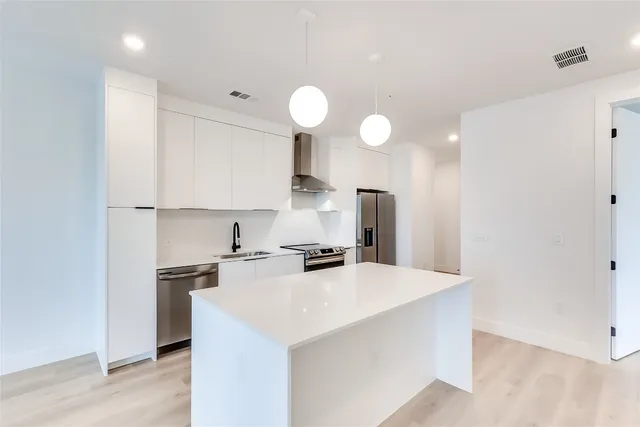 a kitchen with a sink and a stove top oven with wooden floor
