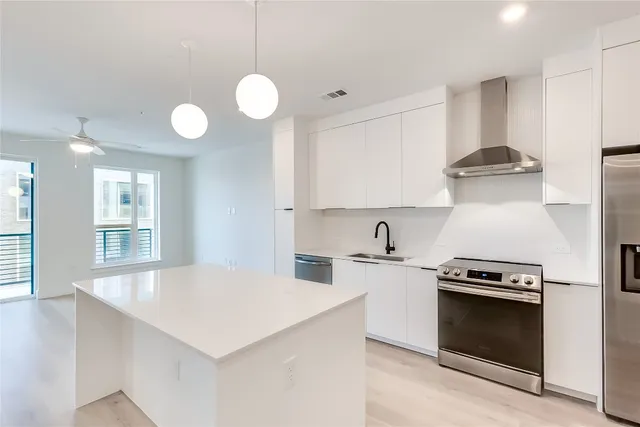 a kitchen with stainless steel appliances a sink stove and refrigerator