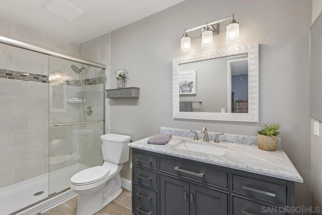 13344 Racquet Court Poway, CA 92064 - Photo 15 of 29 a bathroom with a granite countertop sink toilet and shower