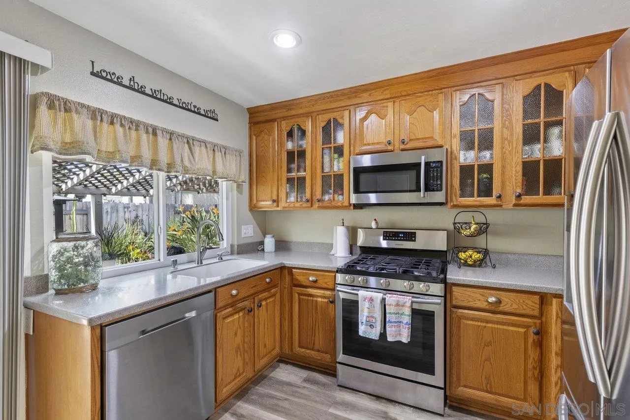 13344 Racquet Court Poway, CA 92064 - Photo 8 of 29 a kitchen with stainless steel appliances granite countertop a stove and a microwave