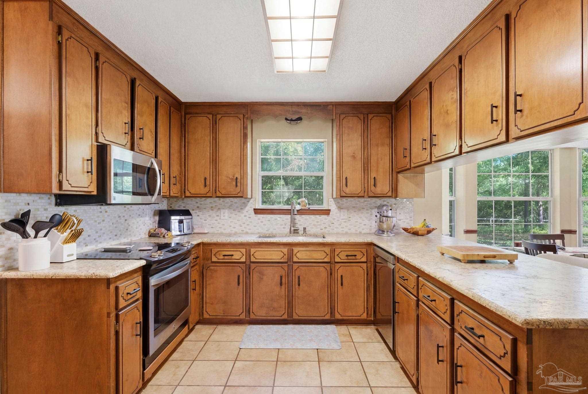 6870 Martin Road Milton, FL 32570 - Photo 12 of 48 a kitchen with a sink stove top oven and cabinets