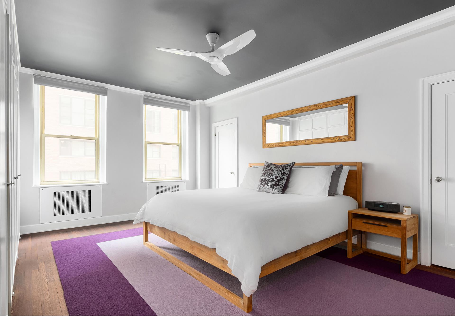 130 East 75th Street, Unit 5A Manhattan, NY 10021 - Photo 6 of 12 a bedroom with a bed wooden floor and window