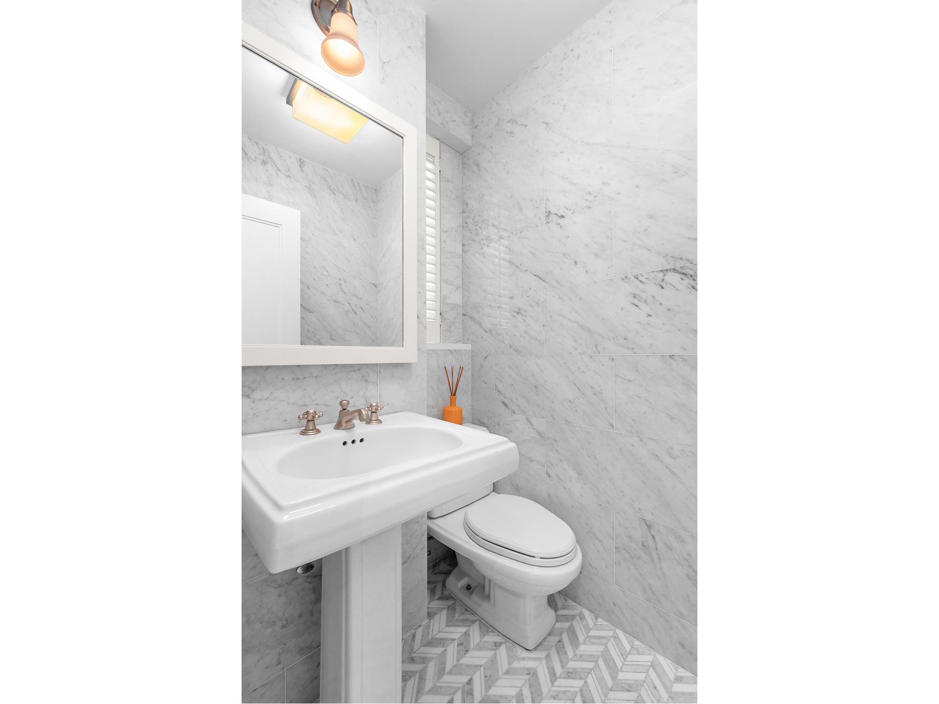 130 East 75th Street, Unit 5A Manhattan, NY 10021 - Photo 10 of 12 a bathroom with a sink a toilet and mirror