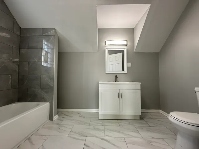 a bathroom with a sink a toilet and bathtub