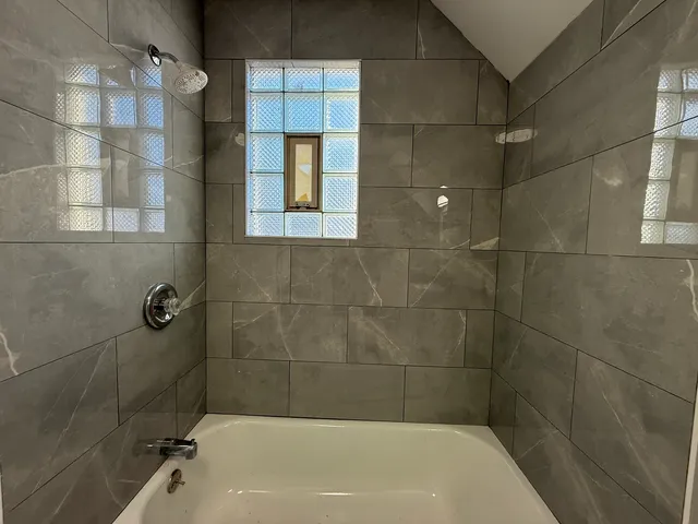a bathroom with a bathtub and shower