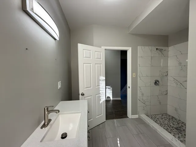 a bathroom with a sink a toilet and shower