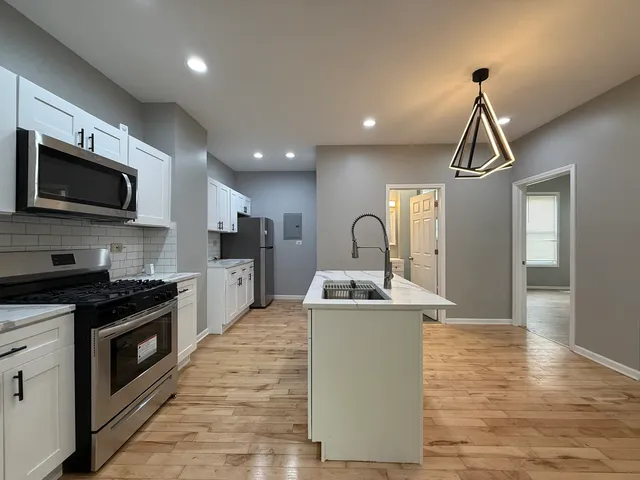 a kitchen with stainless steel appliances a stove a sink and a microwave