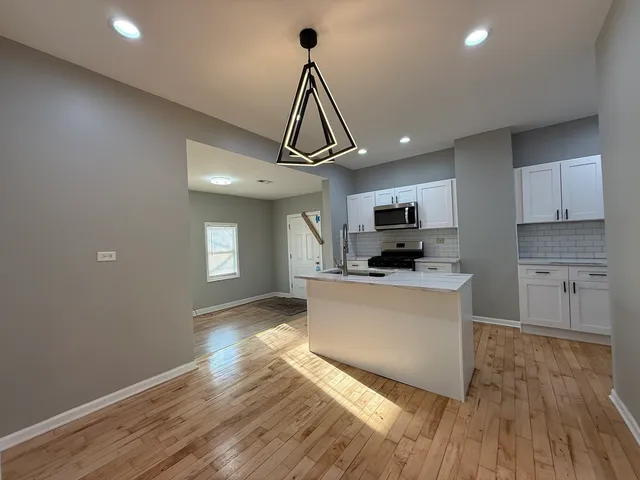 a kitchen with granite countertop a stove and wooden floor