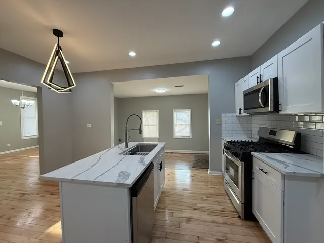 a kitchen with a sink appliances and cabinets
