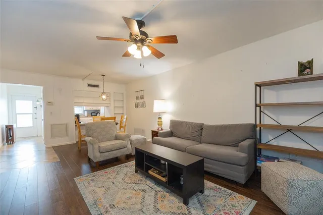 a living room with furniture and a view of kitchen