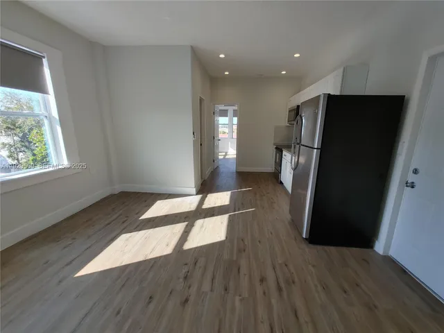 a view of empty room with wooden floor and window