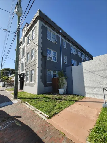 a view of a brick building next to a yard