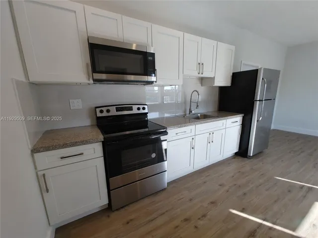 a kitchen with a sink stove and microwave