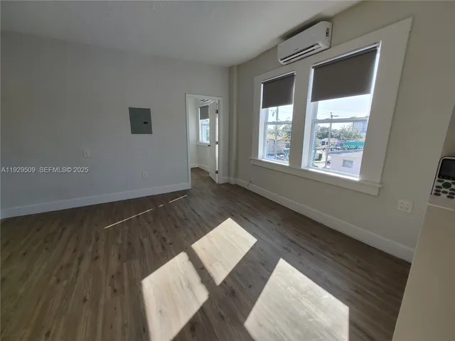 a view of an empty room and wooden floor and a window