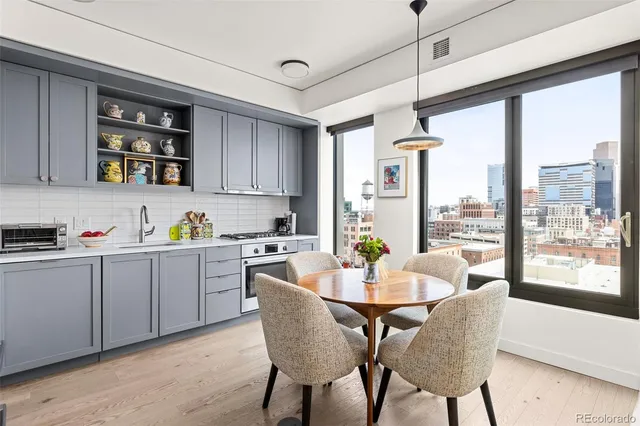 a dining room with furniture and large windows