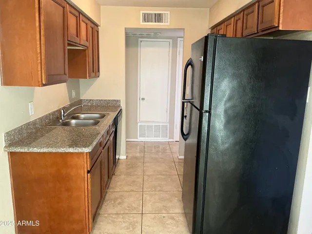 a kitchen with granite countertop a refrigerator and a sink