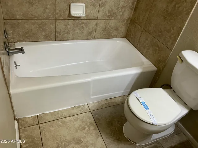 a white bath tub sitting next to a toilet