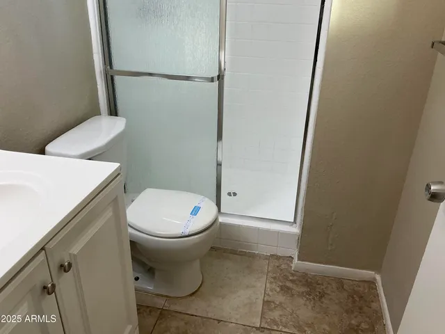 a white toilet sitting next to a white sink and vanity