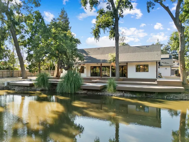 a dining room with wooden floor and chandelier