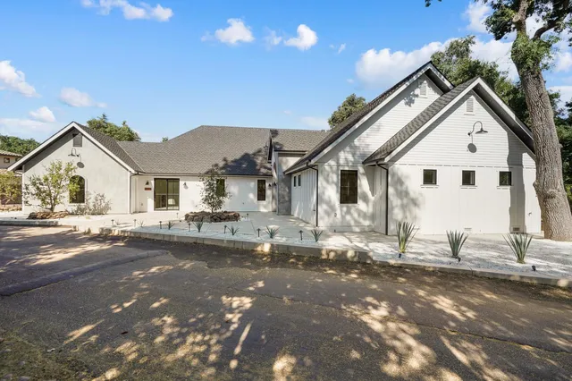 a view of a house with pool fire pit chairs and wooden floor