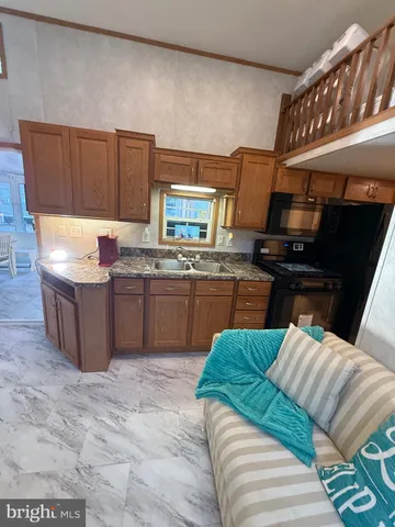 a living room with stainless steel appliances kitchen island granite countertop furniture and a fireplace