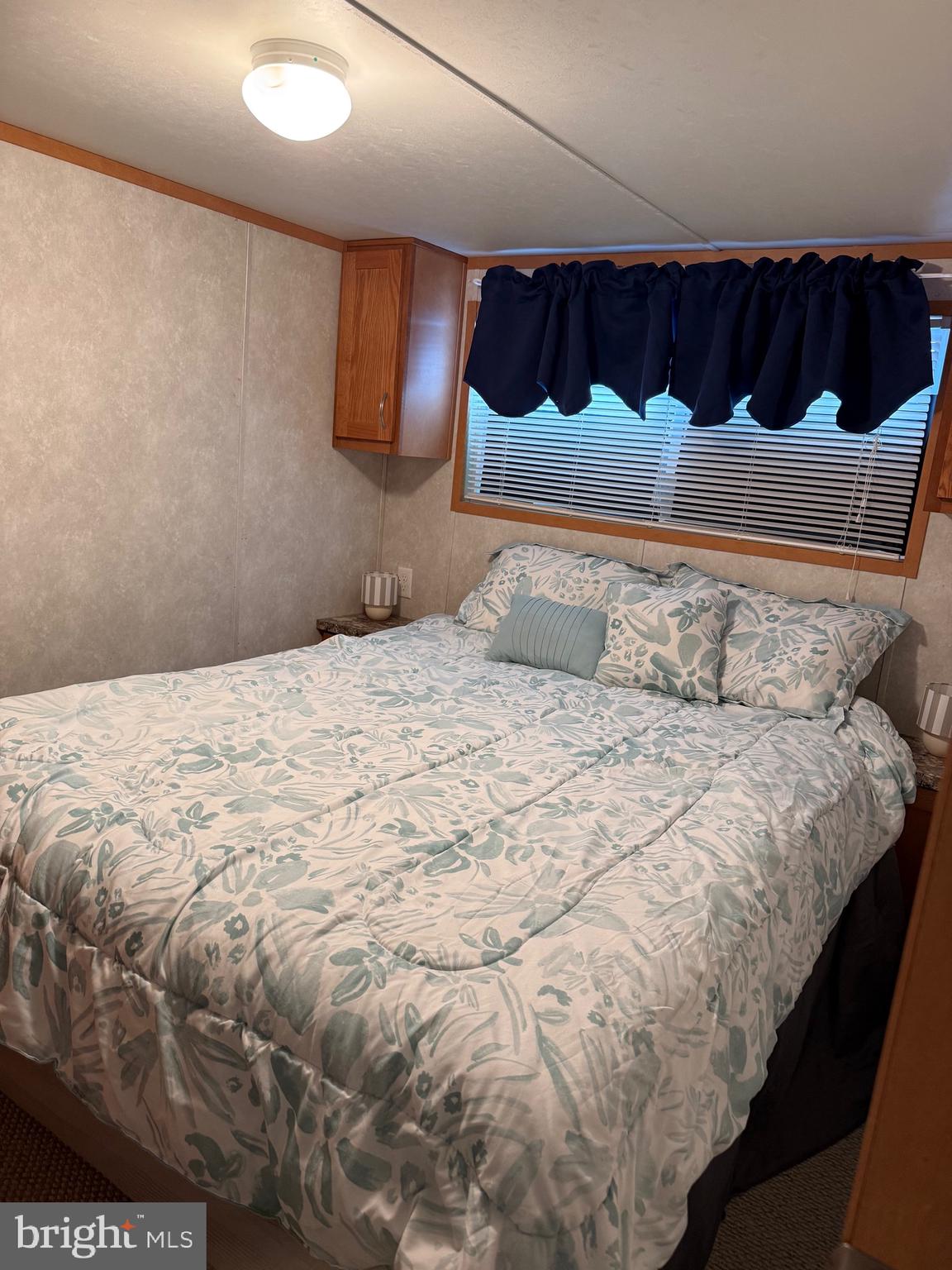 515 Corsons Tavern Road, Unit H61 Ocean View, NJ 08230 - Photo 16 of 19 a bedroom with a bed and a night stand