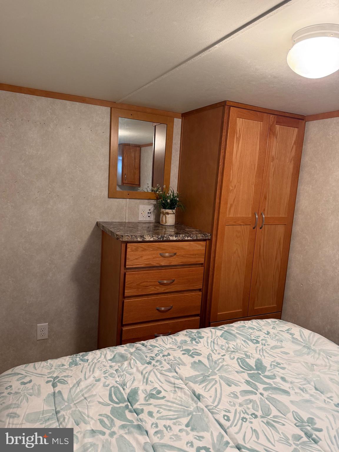 515 Corsons Tavern Road, Unit H61 Ocean View, NJ 08230 - Photo 17 of 19 a bedroom with a bed and a mirror