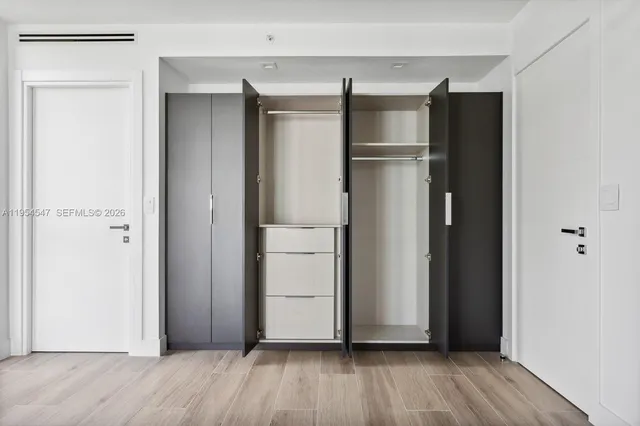 a view of walk in closet with wooden floor
