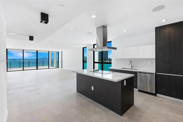 a kitchen with stainless steel appliances granite countertop a sink and a refrigerator