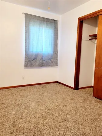 an empty room with a bench and a window