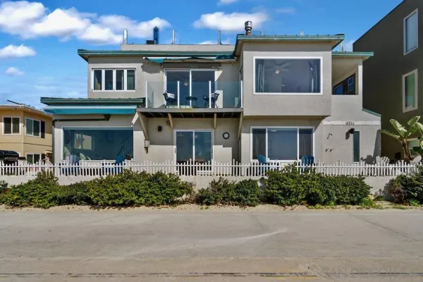 a front view of a house with yard and parking