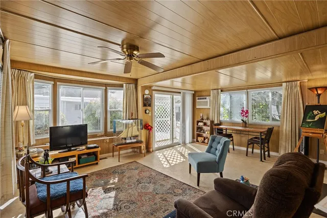 a living room with furniture a flat screen tv and a large window