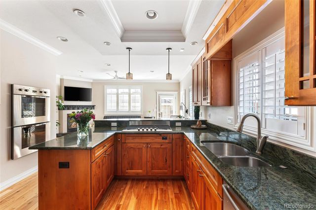 a kitchen with granite countertop a sink stove and cabinets
