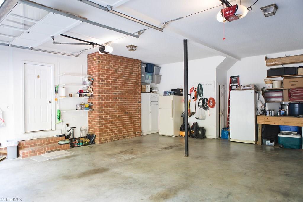 1507 Heathcliff Road High Point, NC 27262 - Photo 29 of 30 Enormous 2 Car Garage with SO MUCH STORAGE & HIGH CEILINGS! Closet, Workbench and Shelving All Remain.