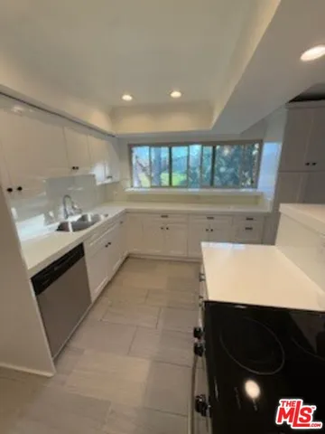 a kitchen with a sink window and cabinets