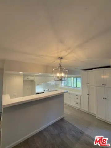 a large kitchen with granite countertop a large white cabinets and a dishwasher