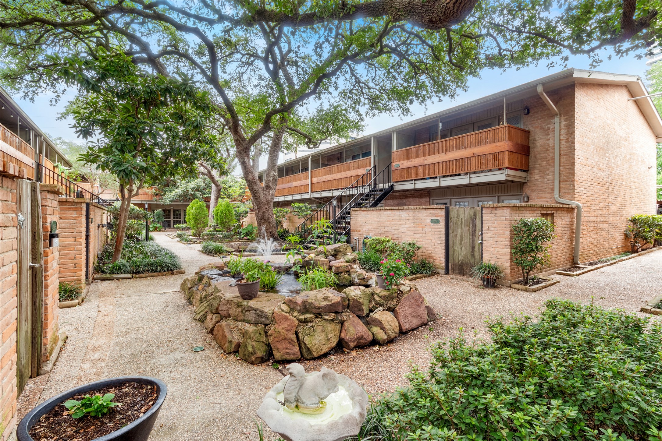 Inviting courtyard with fountain and large trees welcomes you home!