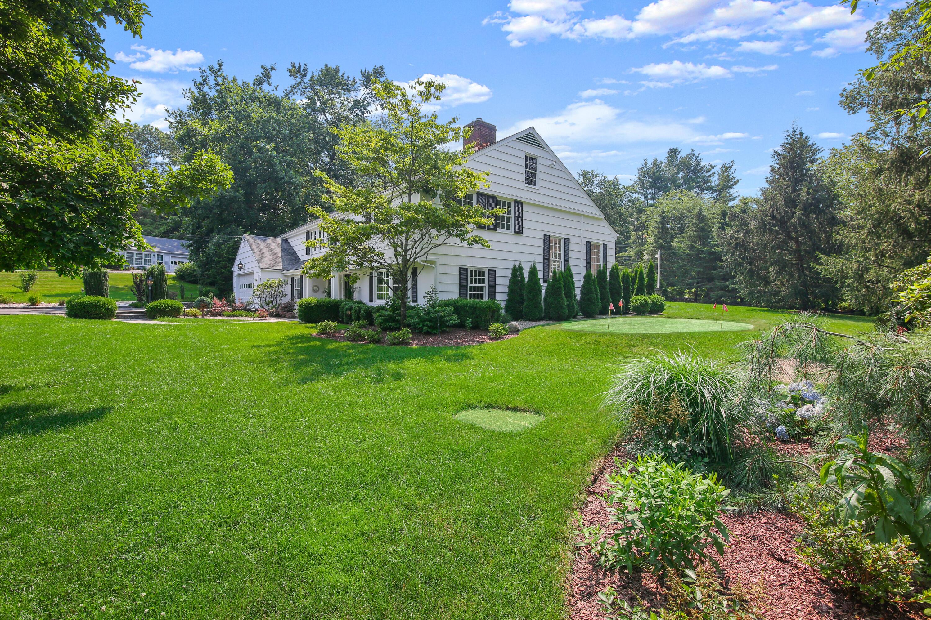 114 Colony Road Darien, CT 06820 - Photo 34 of 40 a view of a white house next to a yard with big trees