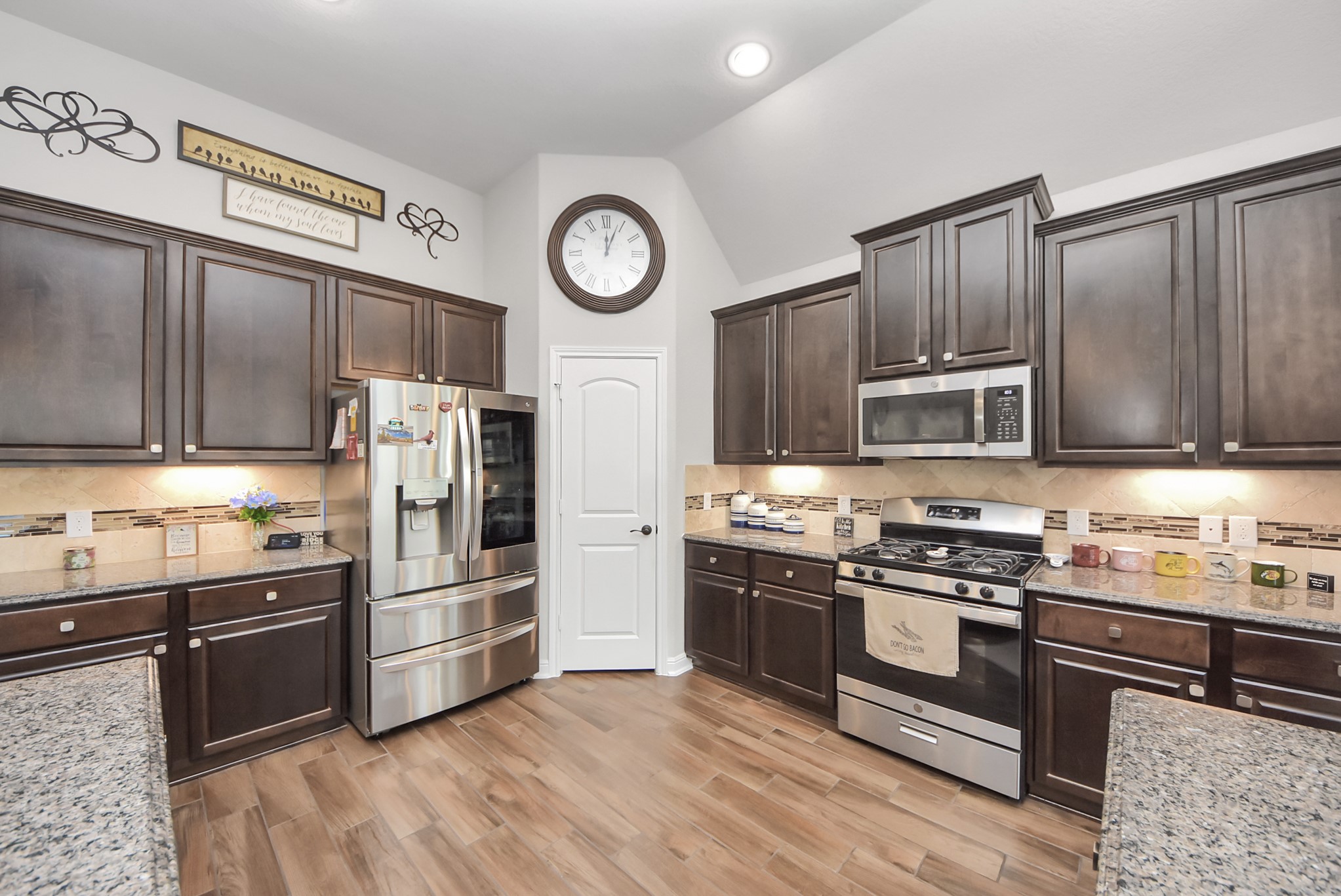 24503 Eucalyptus Way Spring, TX 77373 - Photo 20 of 27 a kitchen with stainless steel appliances wooden cabinets and a stove top oven