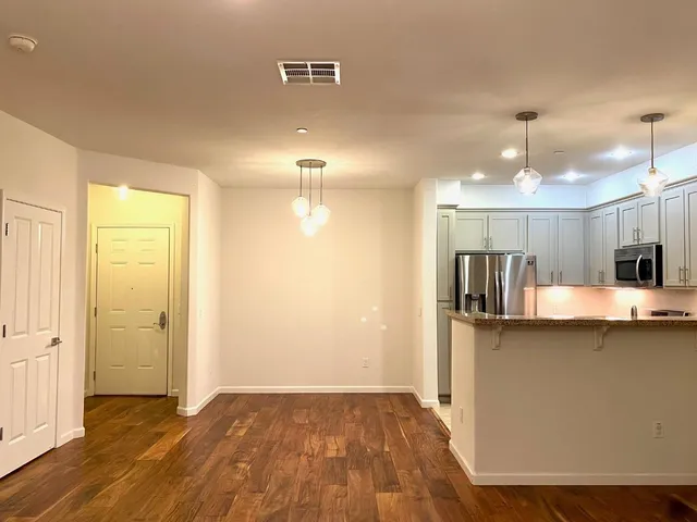 a view of a kitchen with a sink and wooden floor